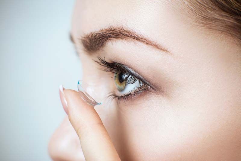 Frau setzt sich qualitative Kontaktlinsen ein in Salzburg